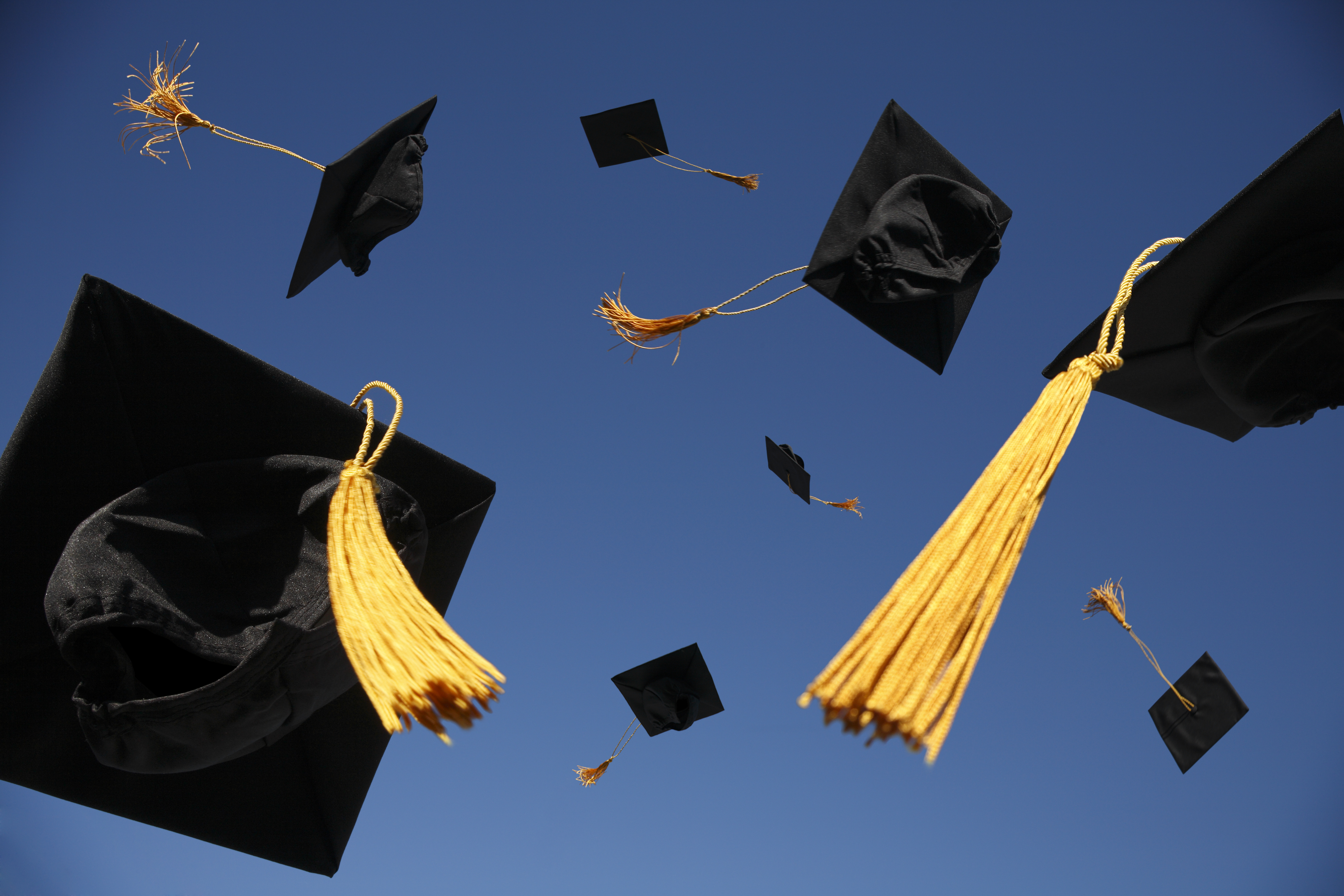 Graduation caps flying in the air