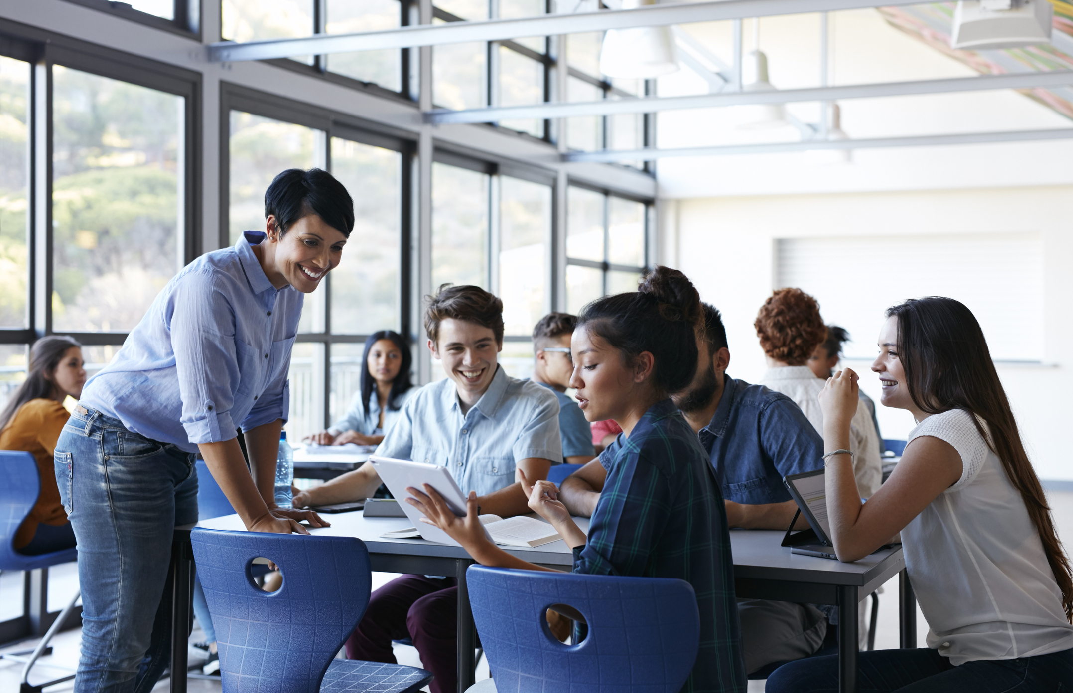 Teacher assisting group of students in classroom