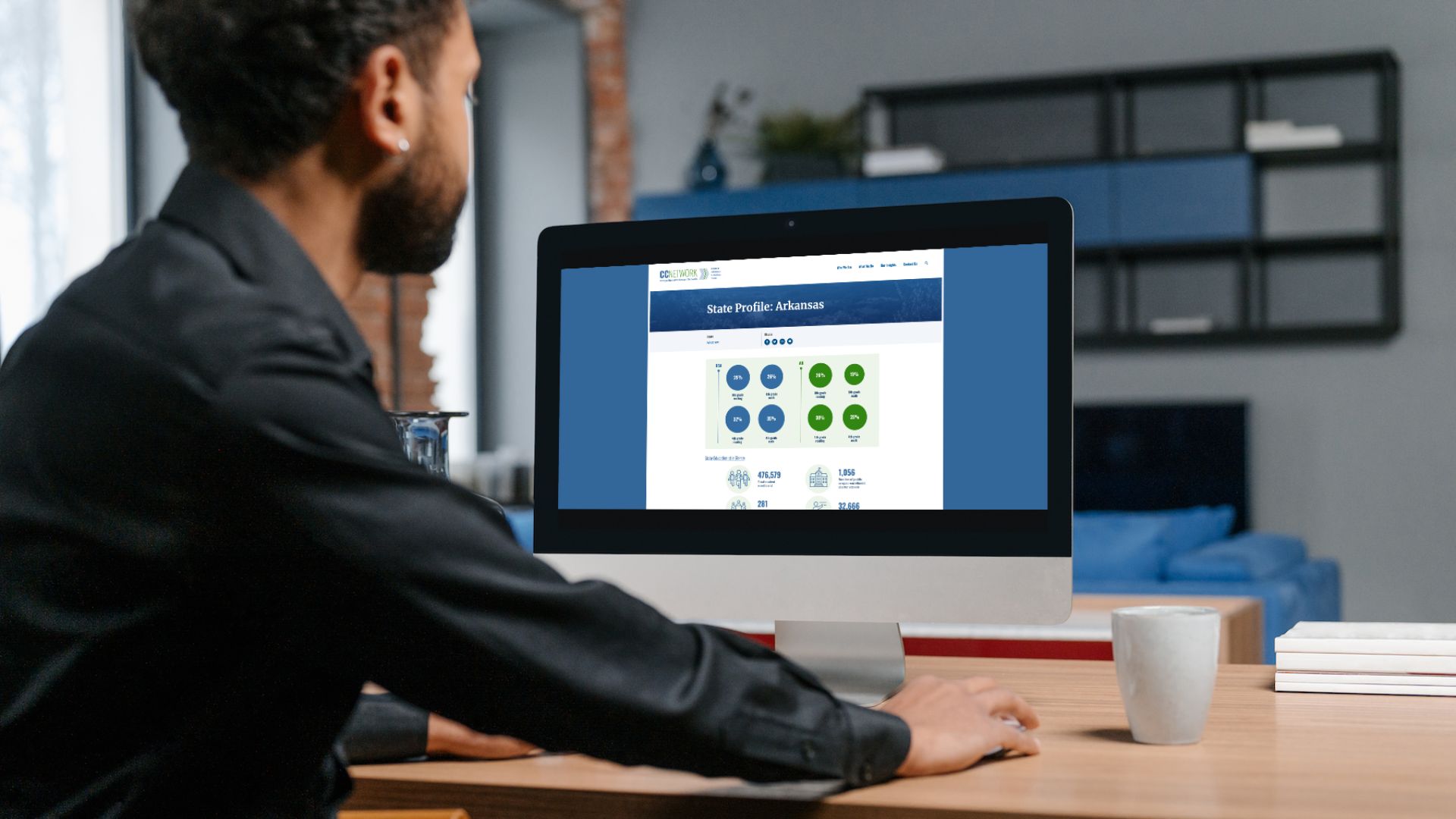 Person sitting at desk looking a computer screen of a state profile.