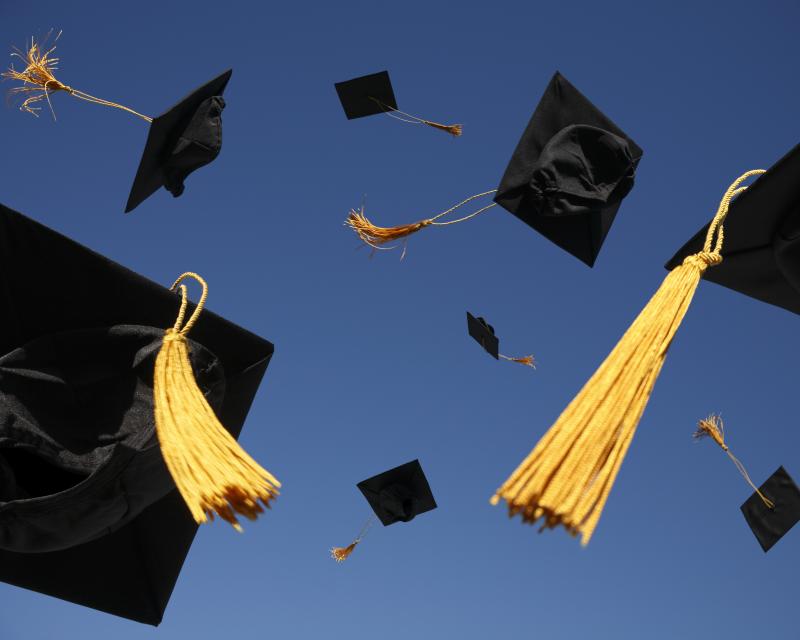 Graduation caps flying in the air